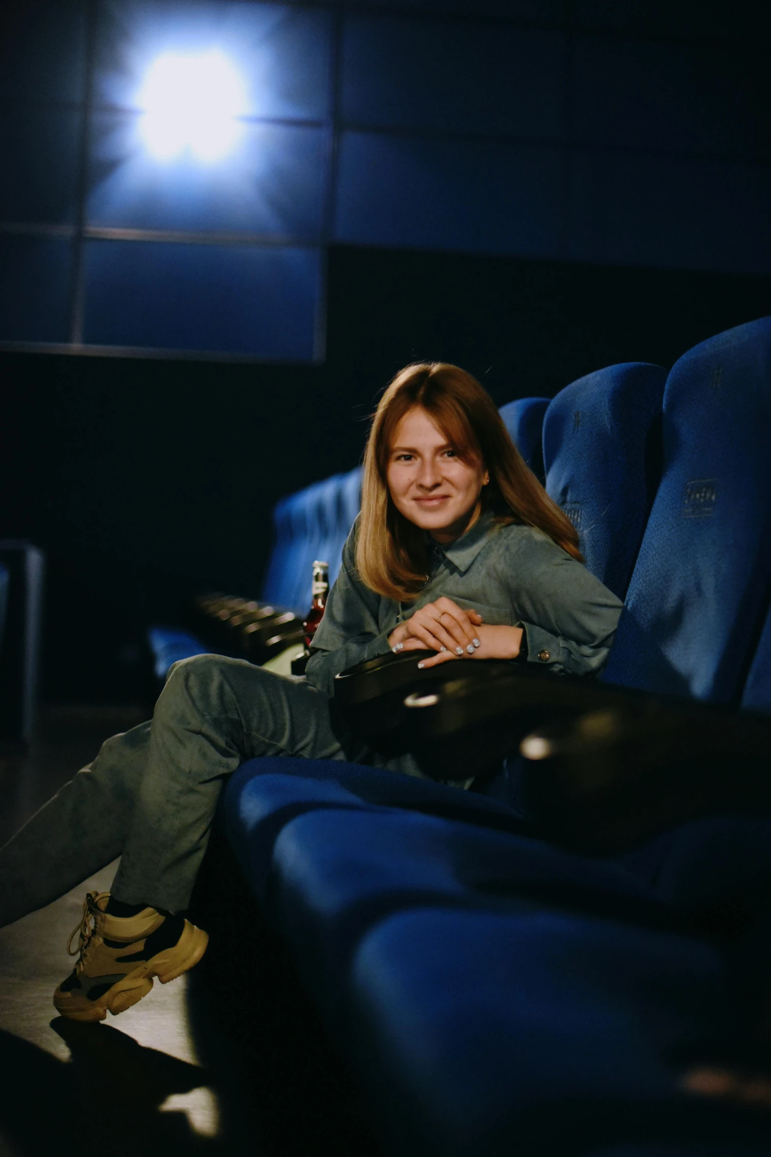 a woman is sitting down in a theater