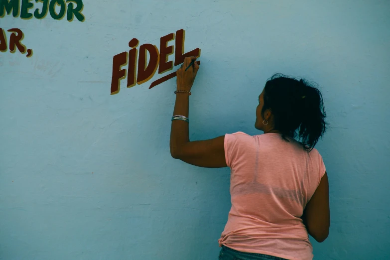 a woman writing on the side of a wall