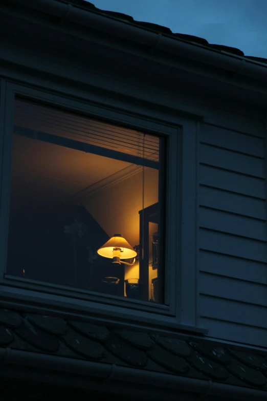 the lamp is on at night time in the window