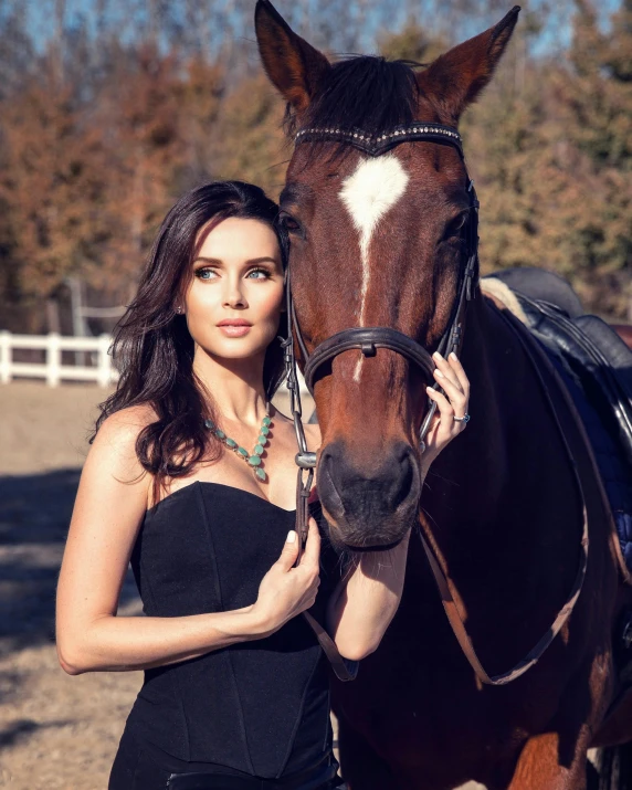 the young woman is posing with her horse