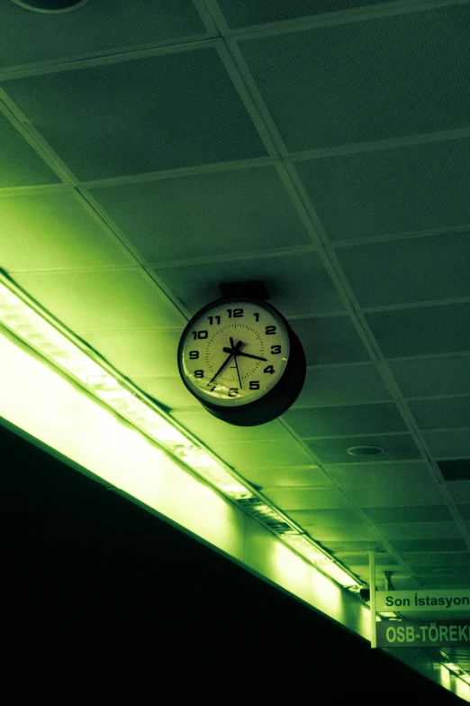 clock is lit up in the ceiling next to the wall
