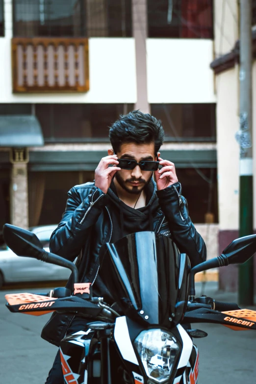 a man in black jacket sitting on top of a motorcycle