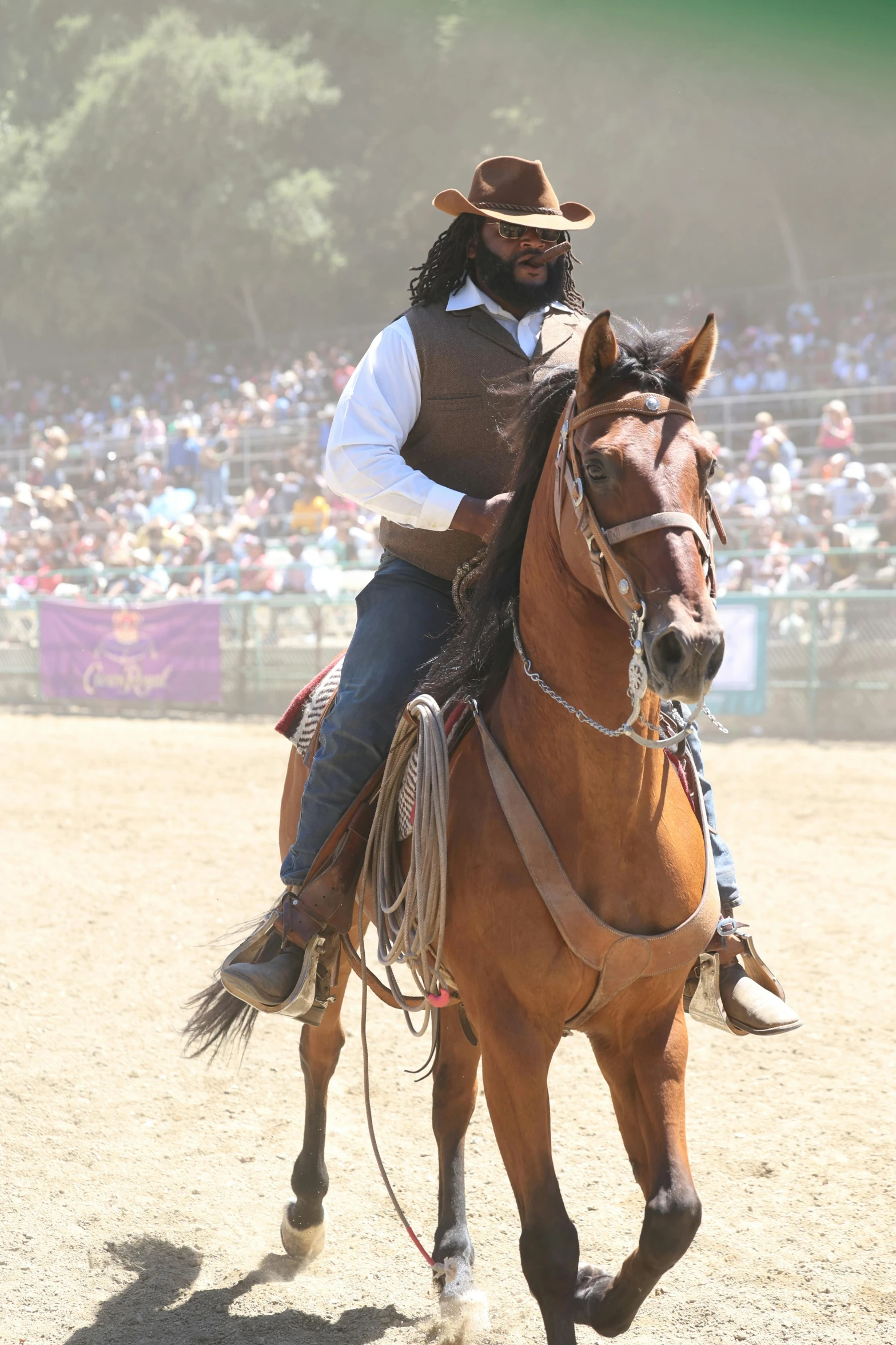 a cowboy on horseback with fans and spectators