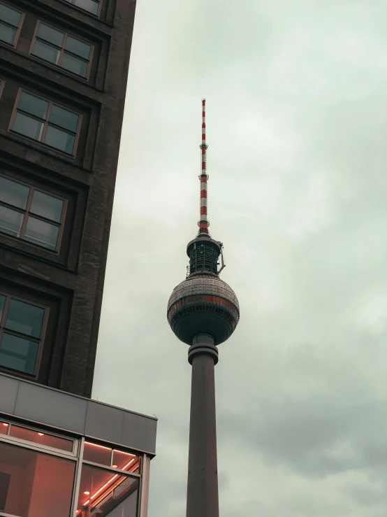 the television tower is against a very cloudy sky