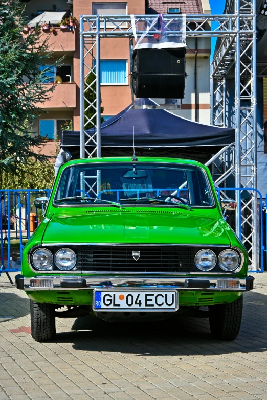 a small green car parked in front of a building