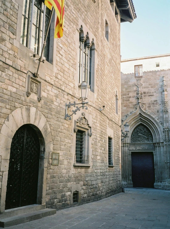 a flag on a pole near the entrance to an old building