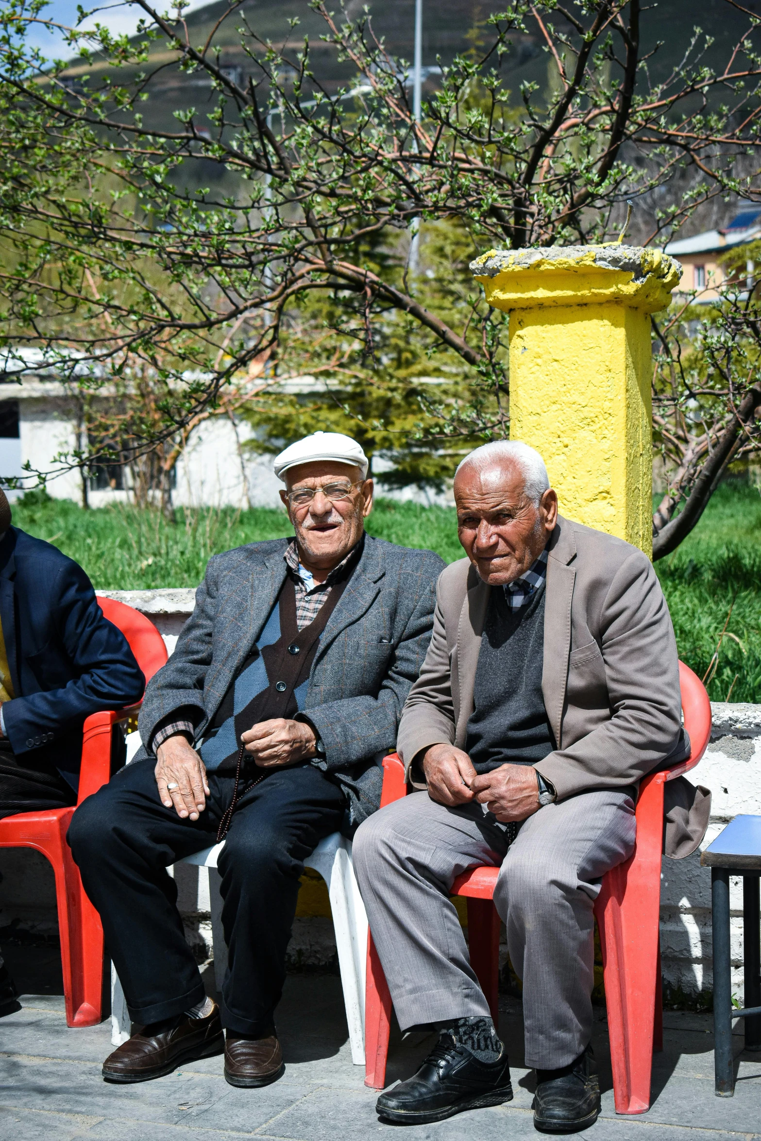 two old men sitting on red and white benches