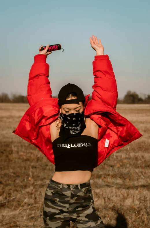 a woman standing in a field holding her arms up