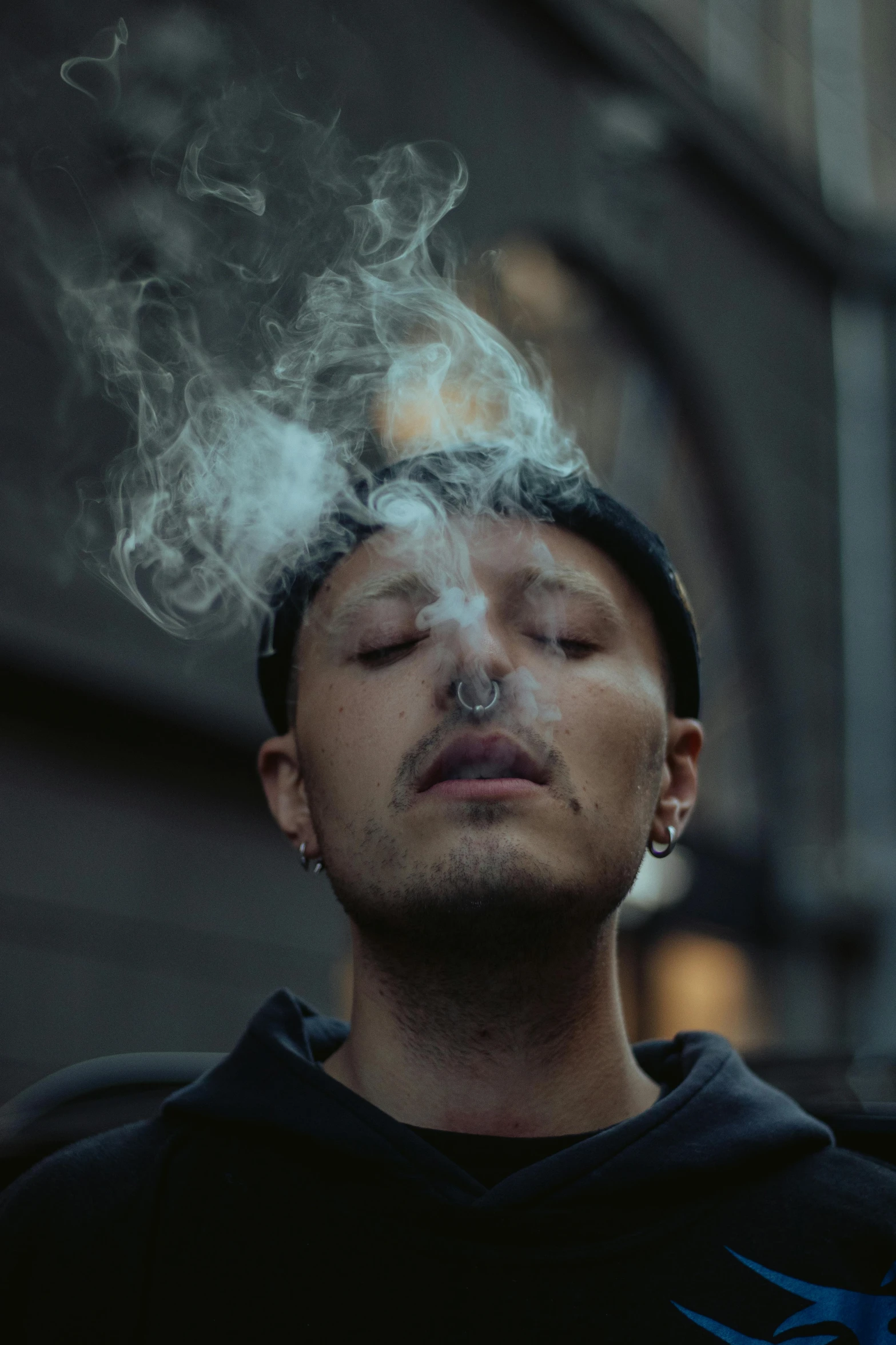 a man smoking a cigarette is shown with only a head and shoulders