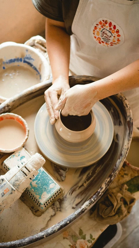 a person creating soing out of pottery with their hands