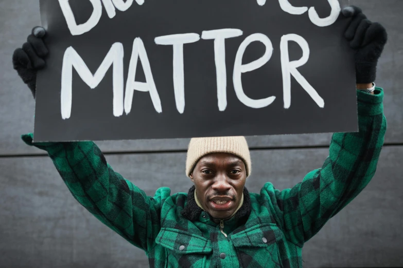 a man holding up a sign with words written on it