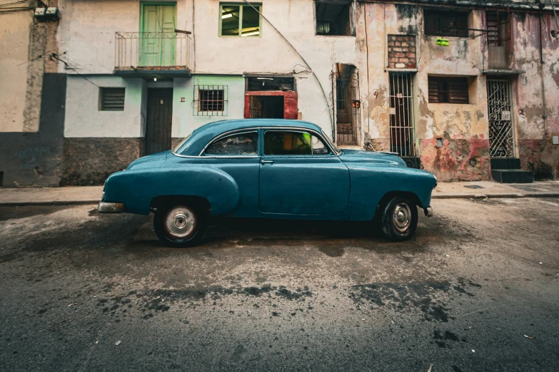 an old car parked in front of some buildings