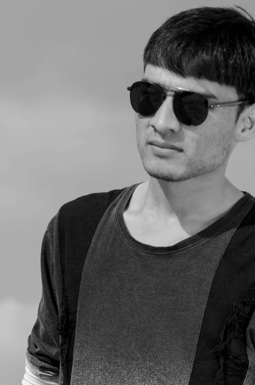 a young man wearing sun glasses, black and white