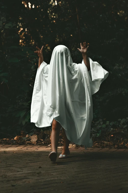 a ghostly figure dressed in white in front of some trees