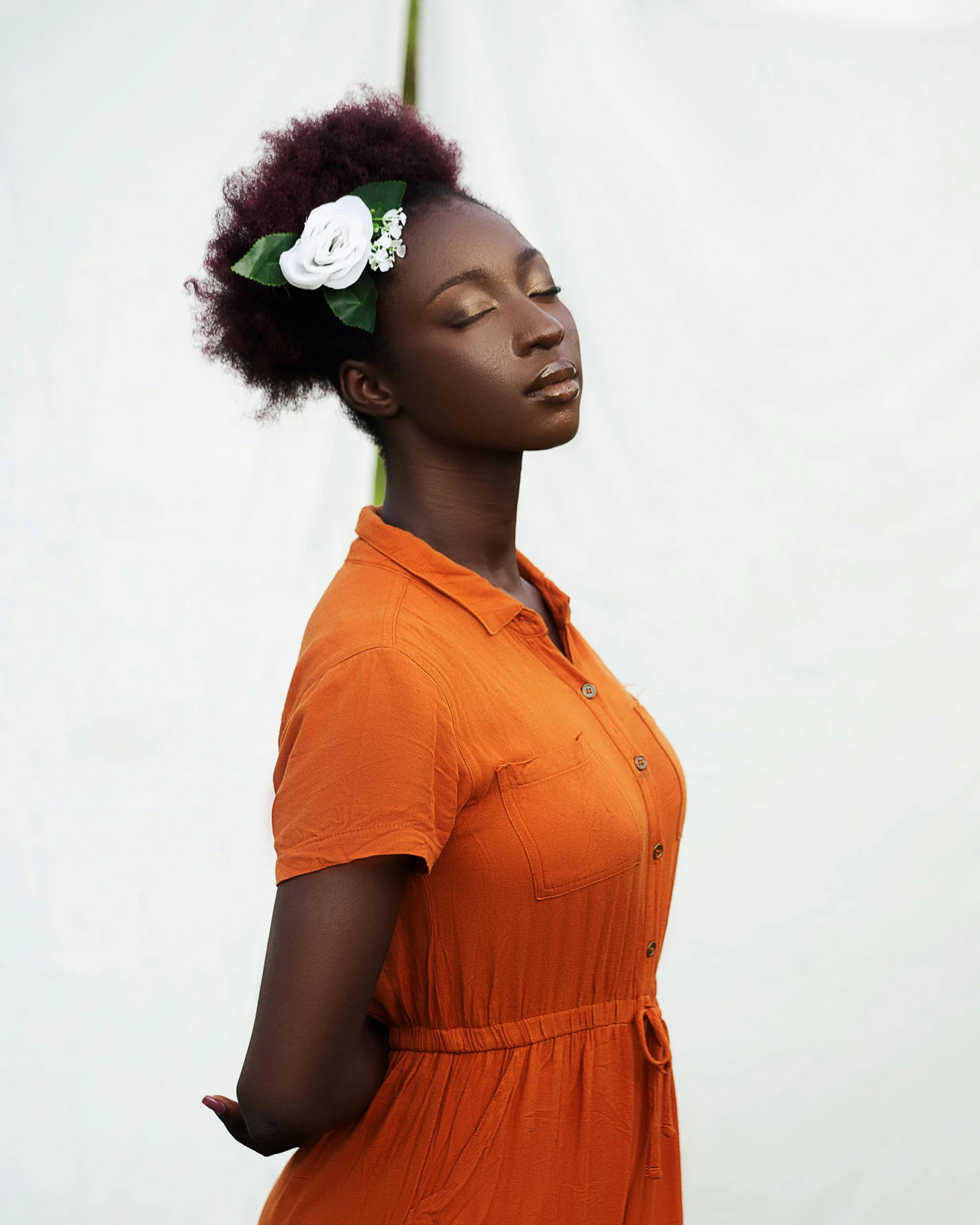 a woman with a flower in her hair looking upwards