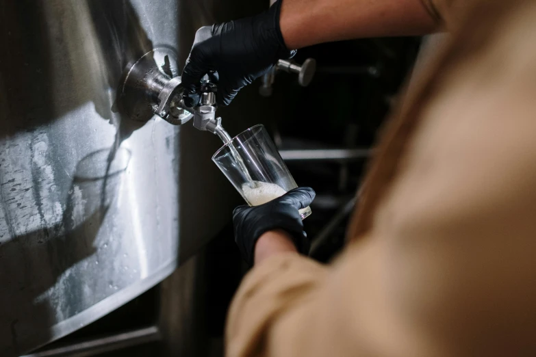 a person pouring soing into a cup