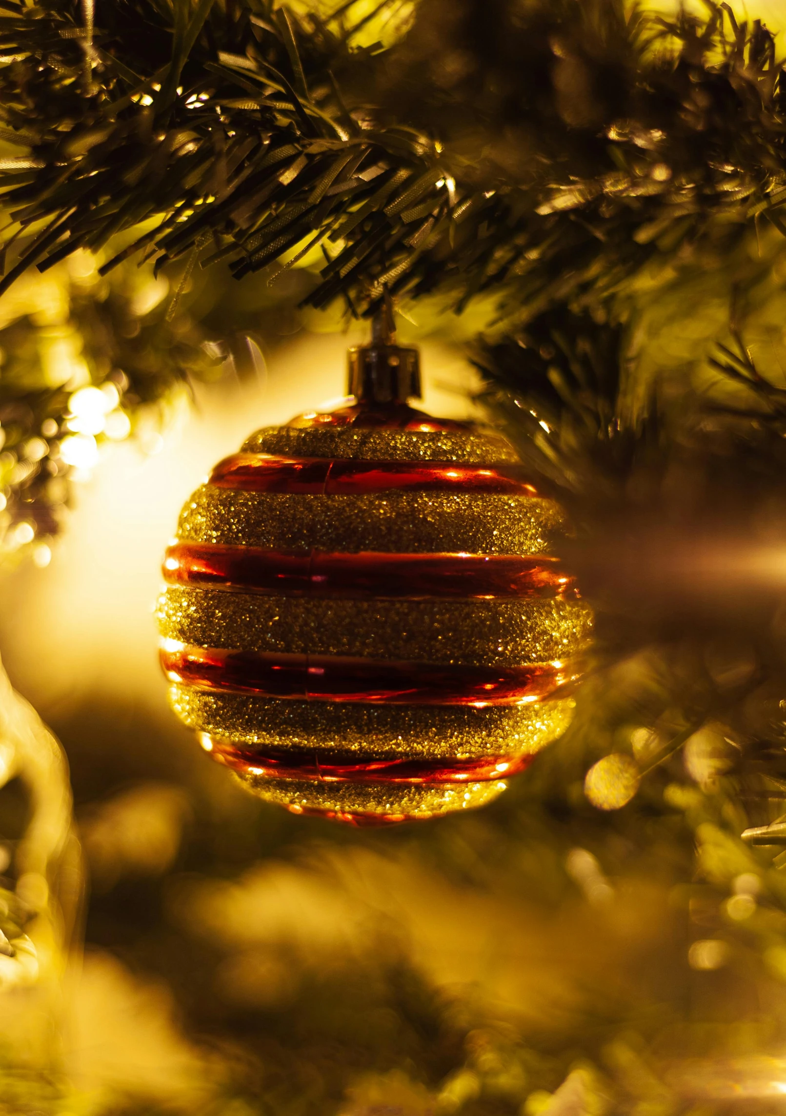 a gold ornament ornament hanging on a tree