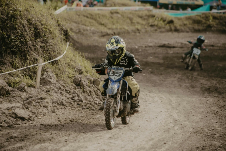 a man on a motorcycle racing down a dirt road