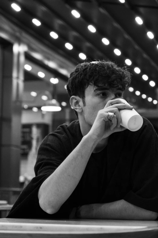 a man with curly hair is sitting at the counter