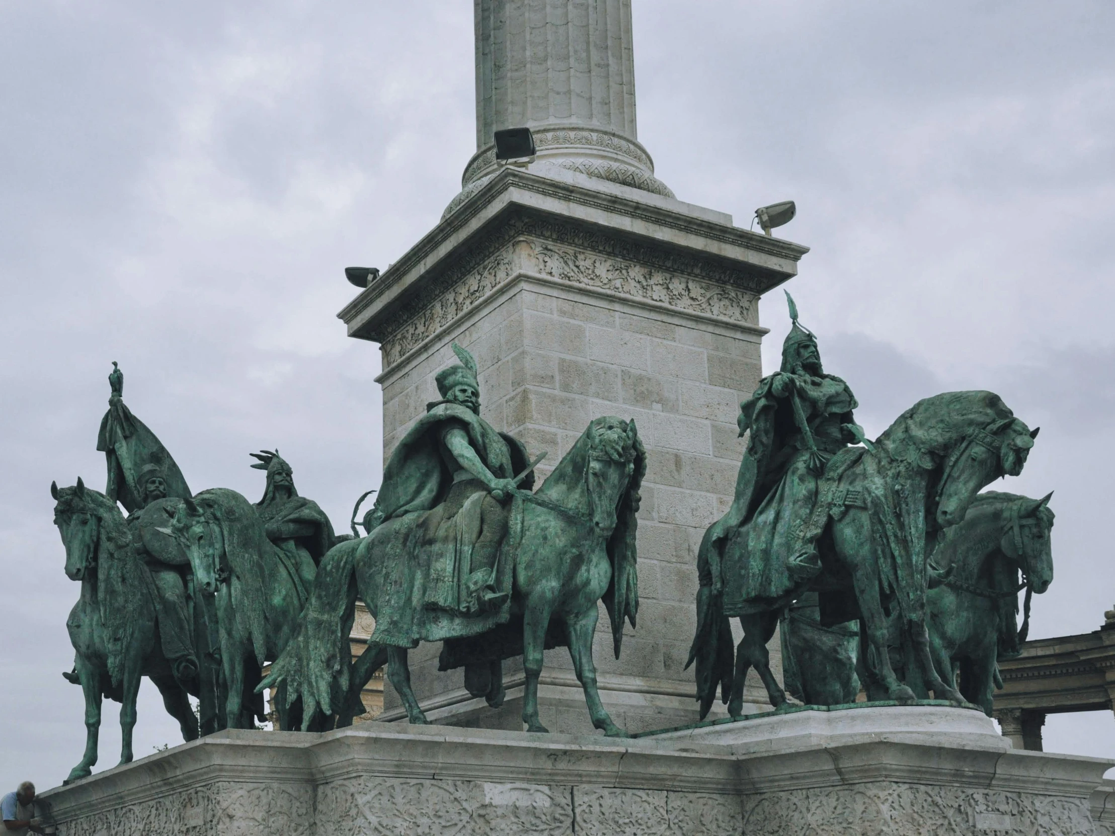 several statues of people riding horses on top of a wall