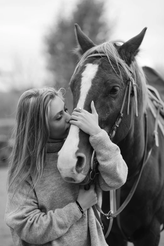 a person hugs a horse as they stand close to each other