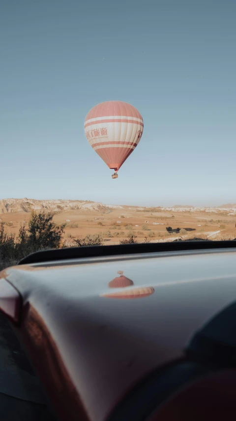 a  air balloon being lifted over the top of a car