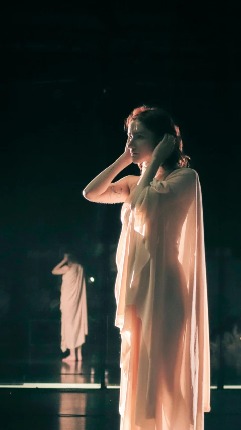 a woman wearing a white dress and covering her face