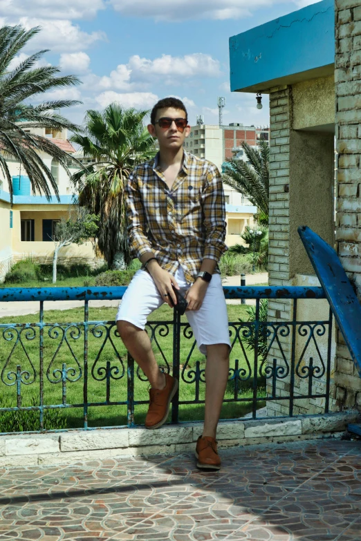 a man wearing sunglasses standing next to a building