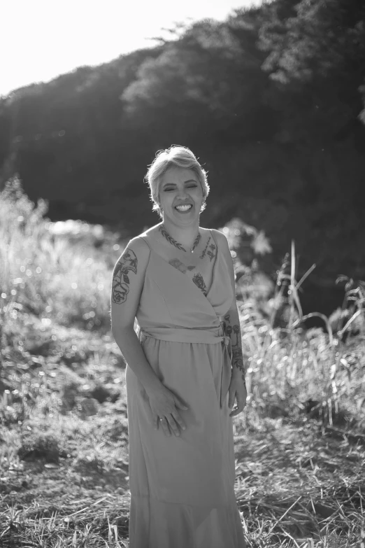 an older woman wearing a dress in the grass