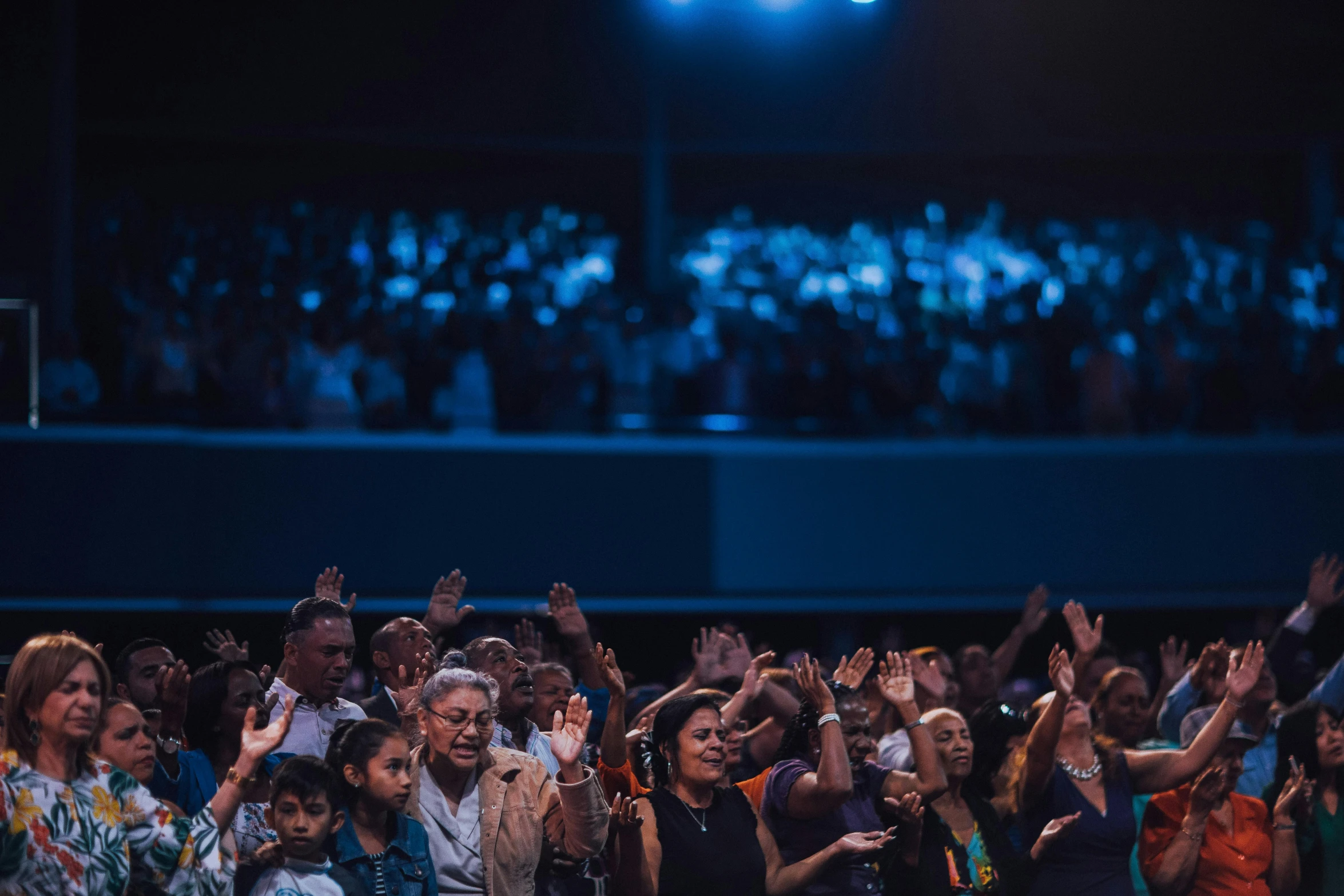 large group of people are clapping for an audience