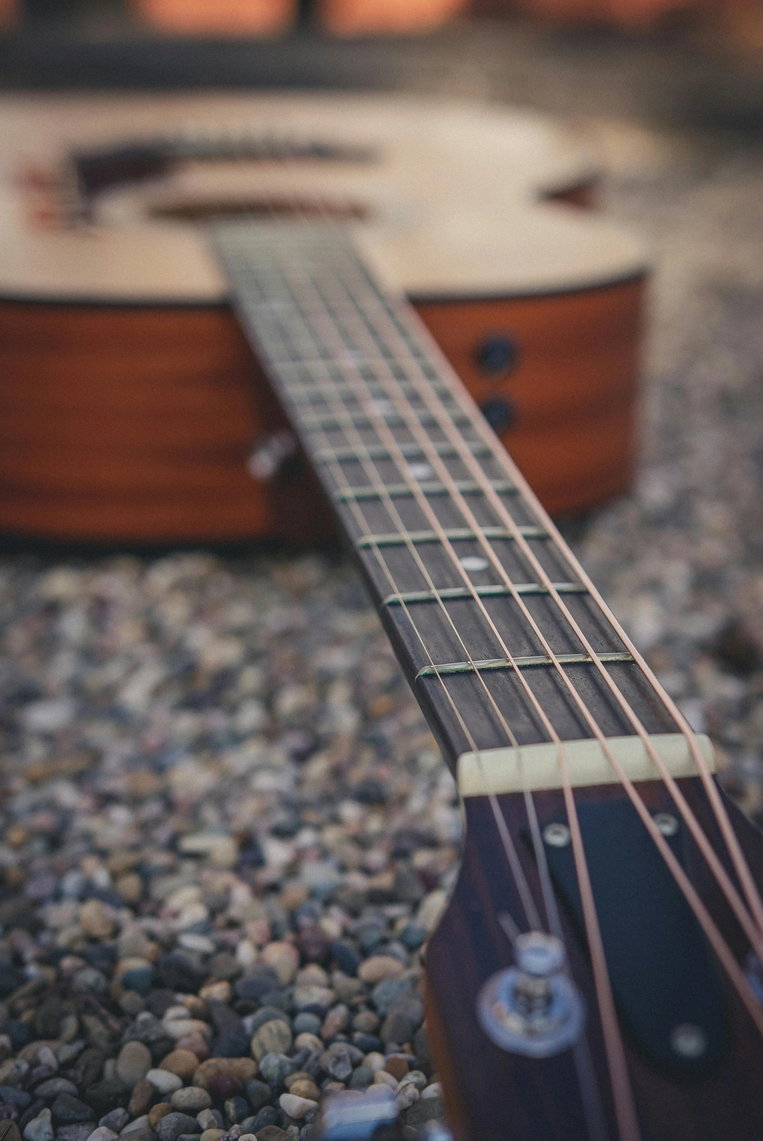 a guitar that is laying on some rocks