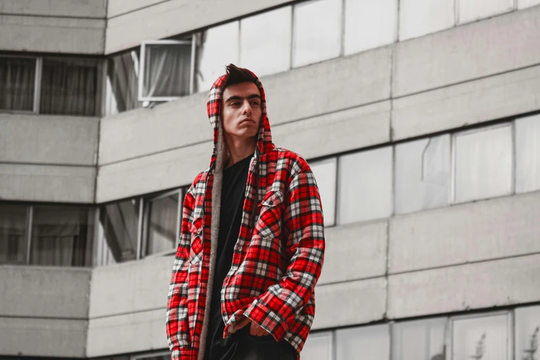 a man in black shirt standing next to tall building