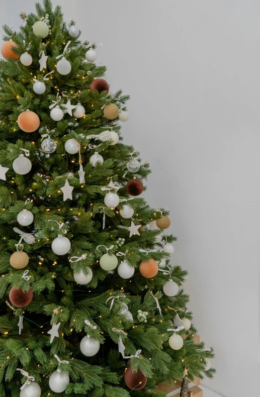 a small christmas tree with ornaments around it