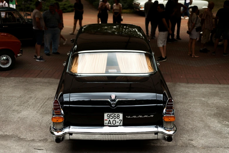 old, restored car with a large window, at a car show