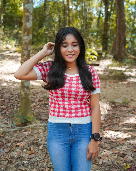 a woman stands in the woods posing for a picture