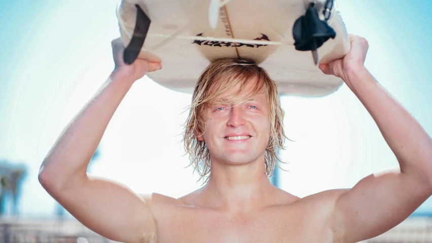 a man is standing in the water holding a surf board on his head