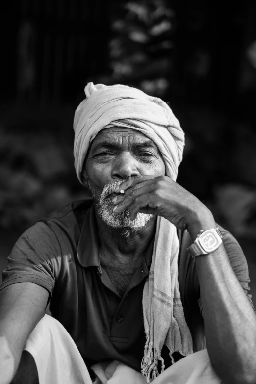 an old man sits while eating food