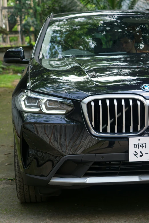 a black bmw suv parked on a driveway