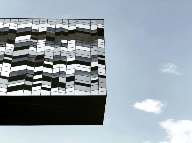 an unusual, cube - shaped building with clear blue skies