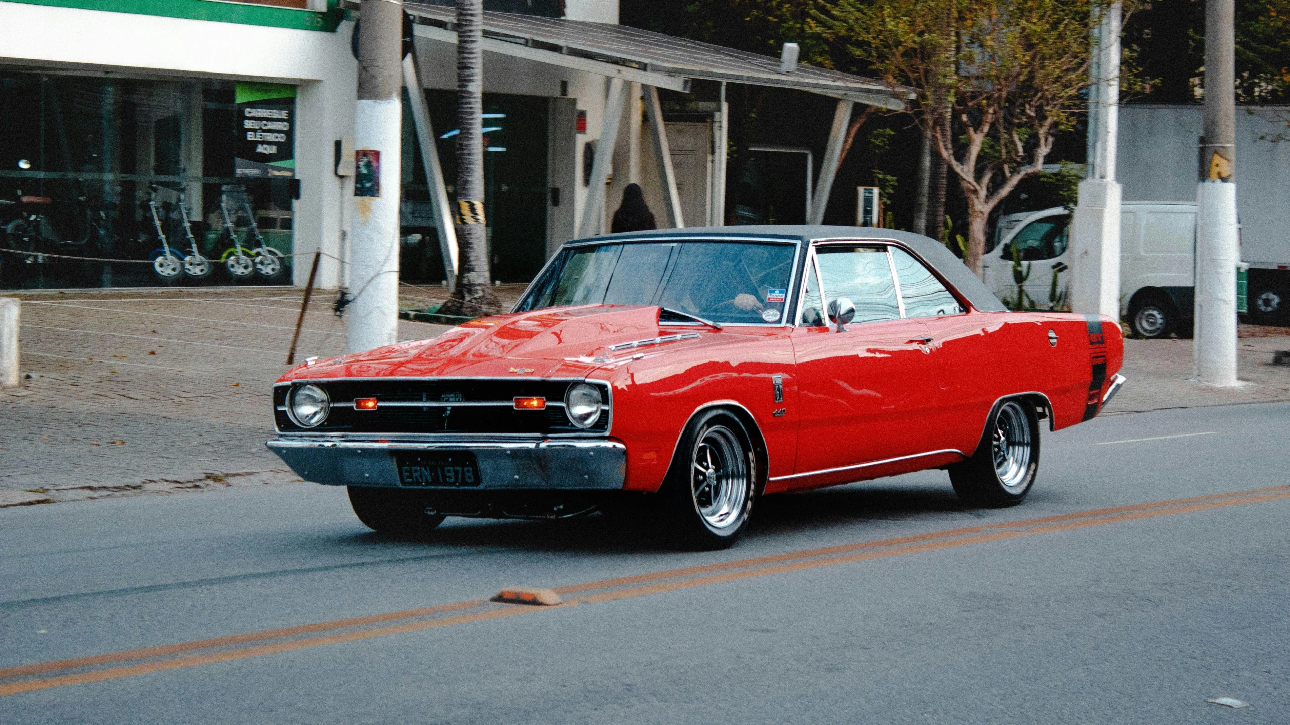 an old car with red paint on the side of a street