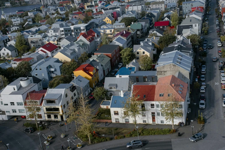 several colorful houses and parking lots around a town