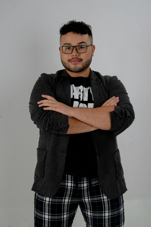 a man wearing glasses and a black shirt standing with his arms crossed