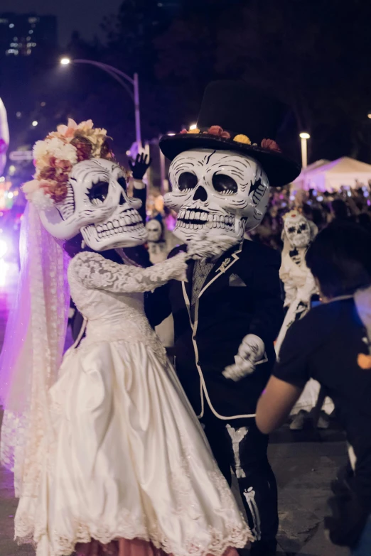 a couple in skeleton makeup and wedding clothes