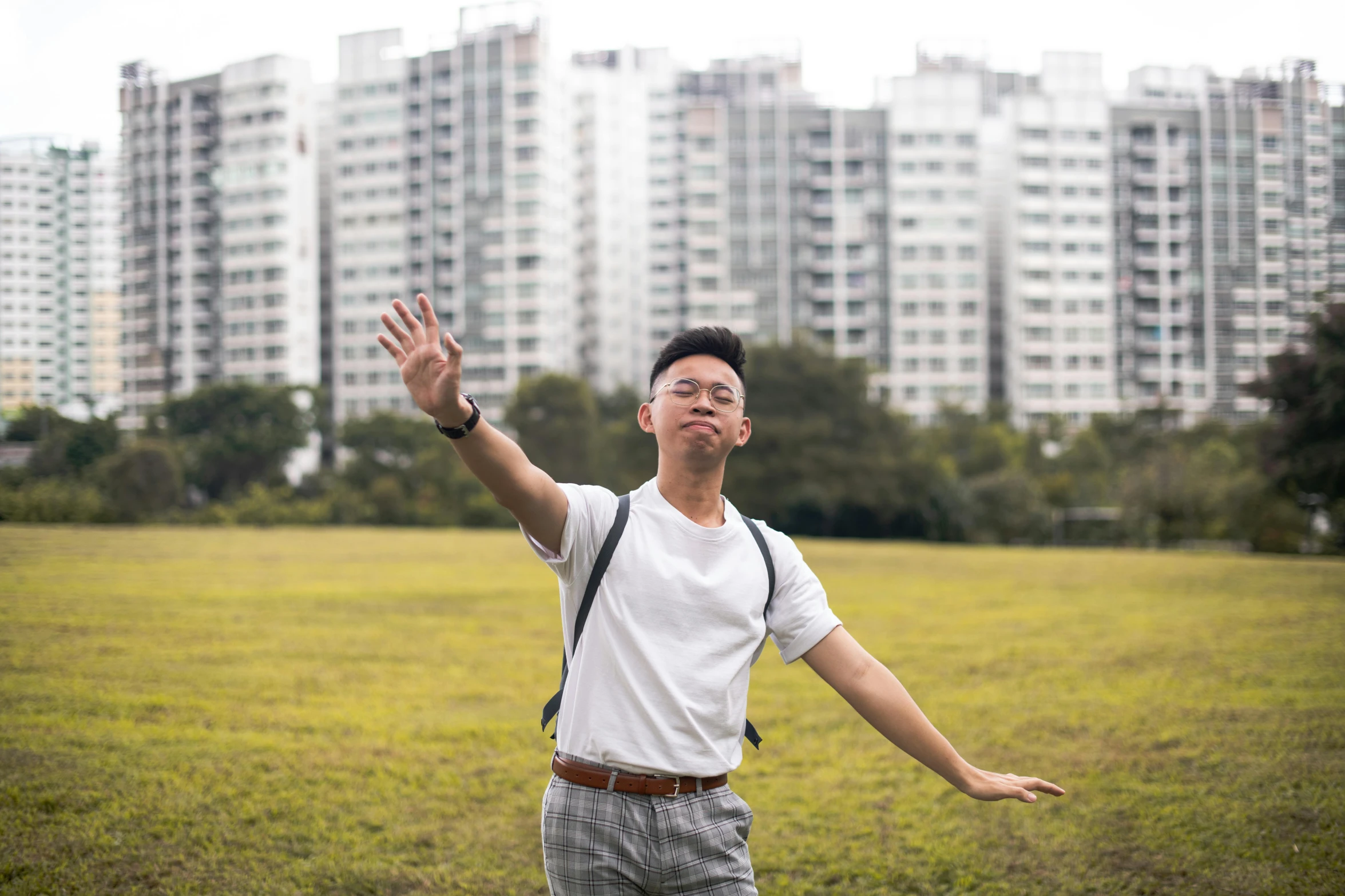 a man in a field tossing his arm up