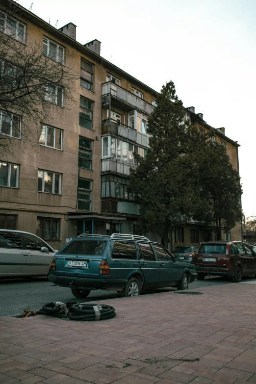 cars parked on the side of a street next to a parking lot