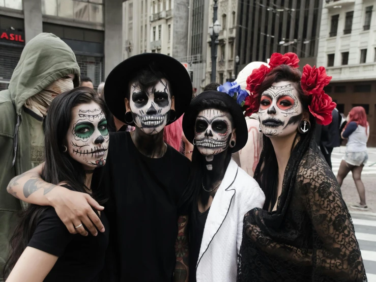 two women and two men with fake skull make up as one man takes pictures