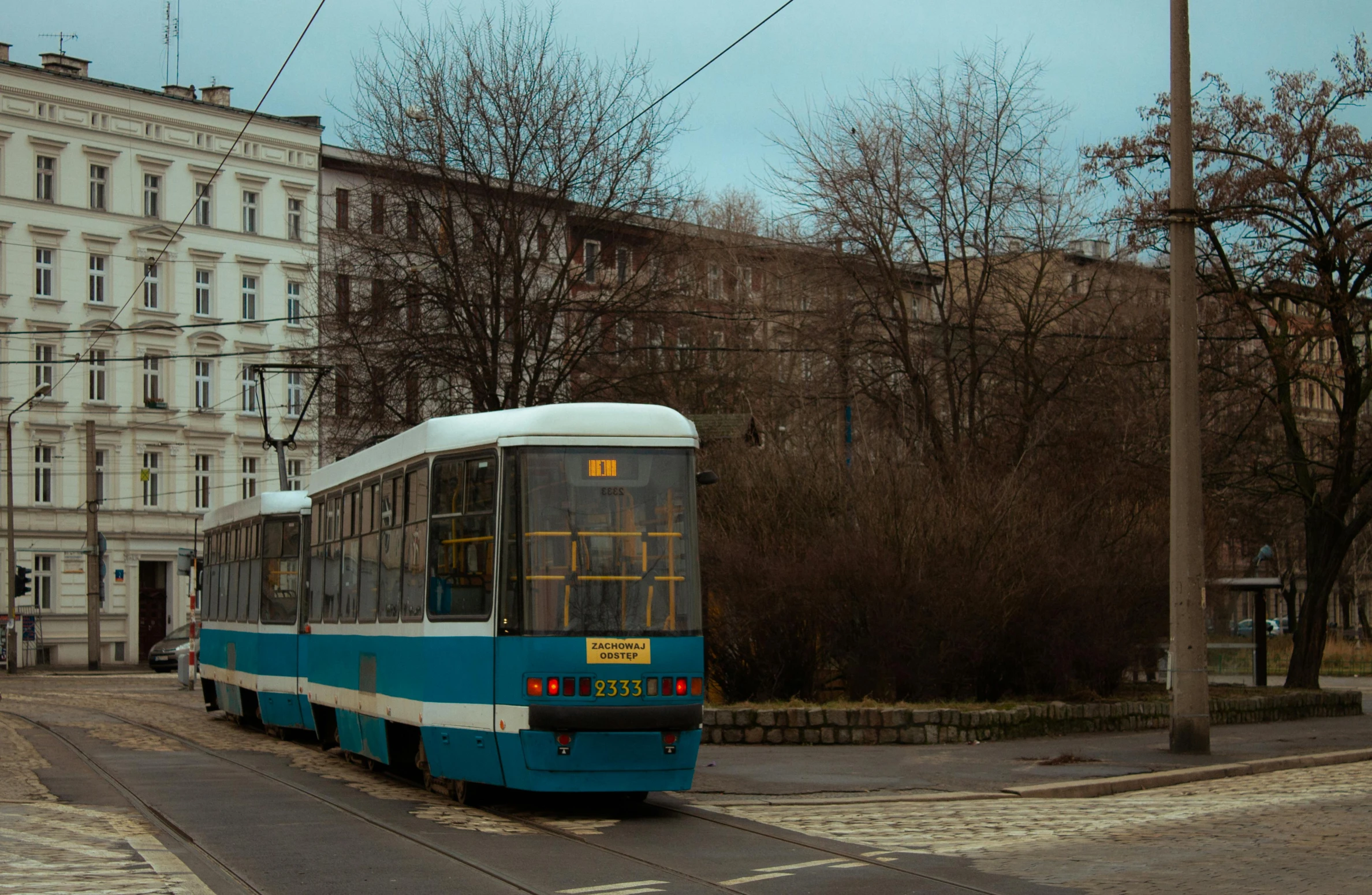 a bus sitting on the side of a road next to a tall building