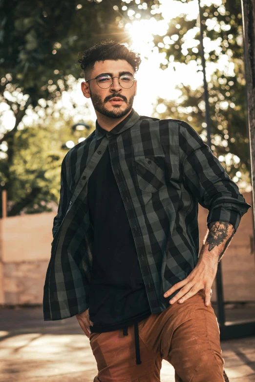 man standing outdoors, dressed in brown pants and black shirt