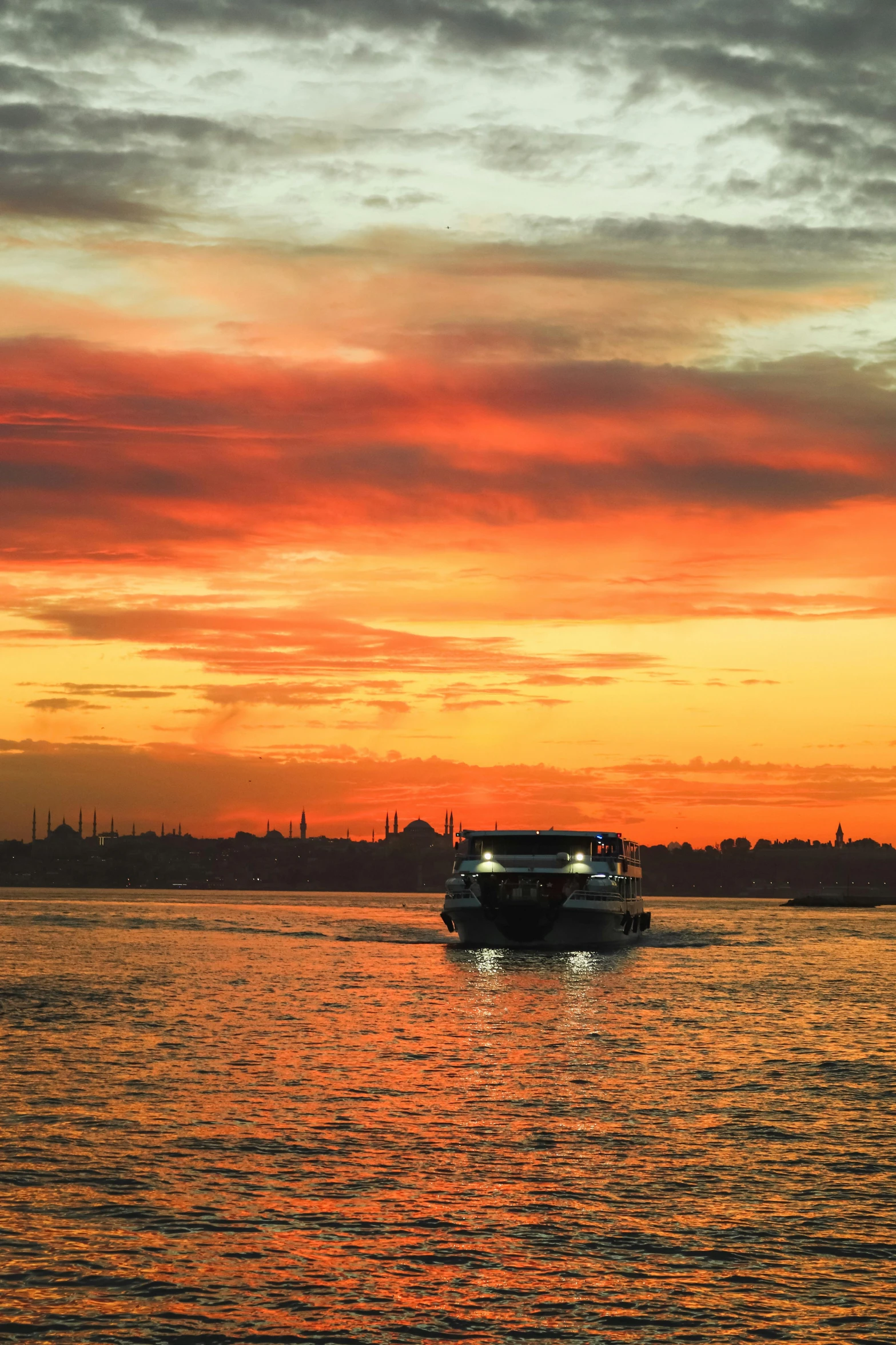 an image of a ship sailing in the water at sunset