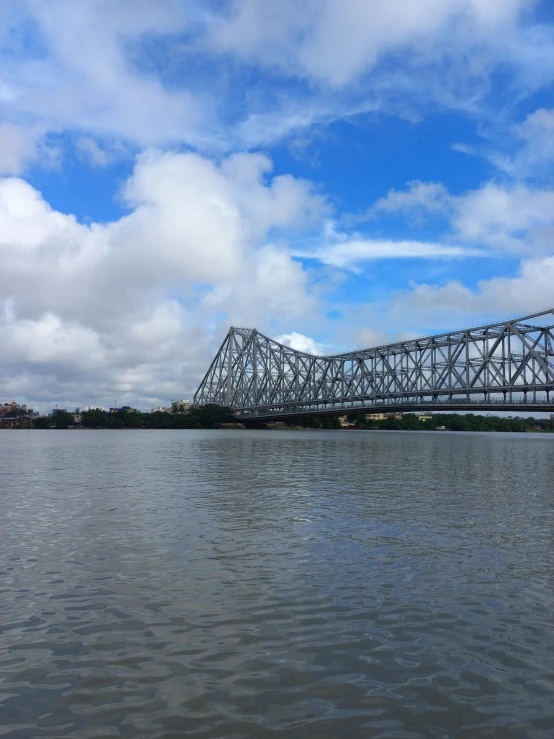 a very big bridge over some water with clouds